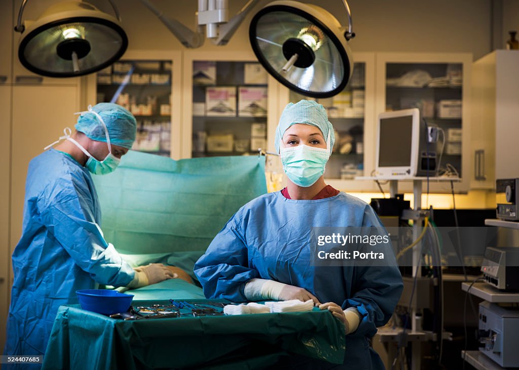 Confident surgeon by colleague operating patient