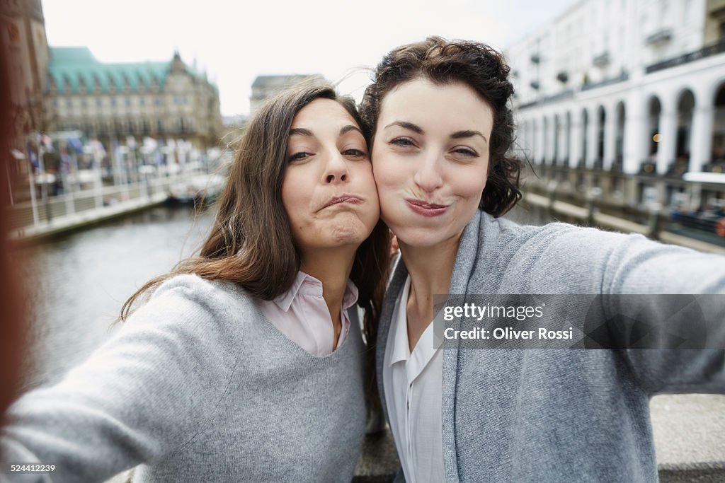 Portrait of two playful young women taking selfie