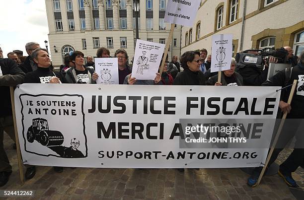 People hold a banner reading "thank you Antoine" as they demonstrate outside the courthouse in Luxembourg, on April 26 in support of whistle-blower...