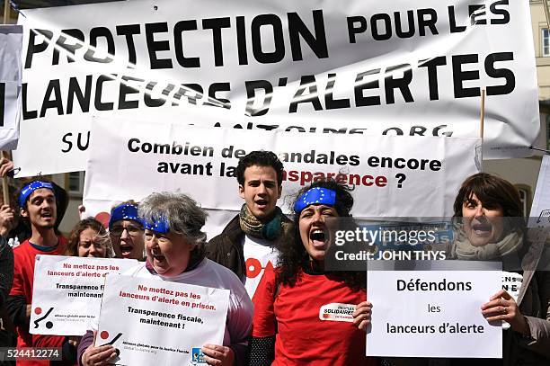 People hold placards reading "stand up for the whistle-blowers", as they demonstrate outside the courthouse in Luxembourg, on April 26 in support of...