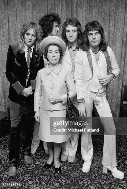 British rock band Queen posing with actress and Queen Elizabeth II look-alike, Jeannette Charles, September 1974. The group are drummer Roger Taylor,...