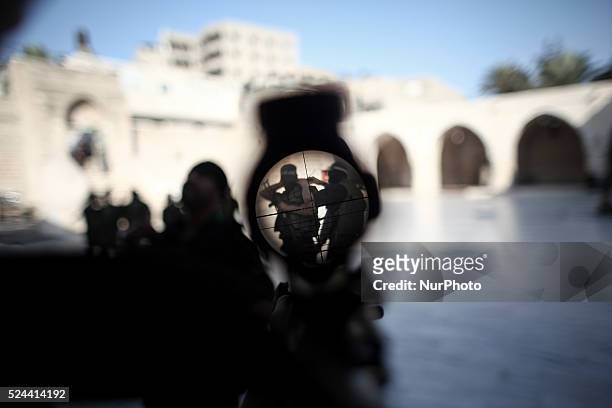 Palestinian boy looks through sniper's weapon for a member of the Ezz Al-Din Al Qassam brigade, the military wing of Hamas, during a march along the...