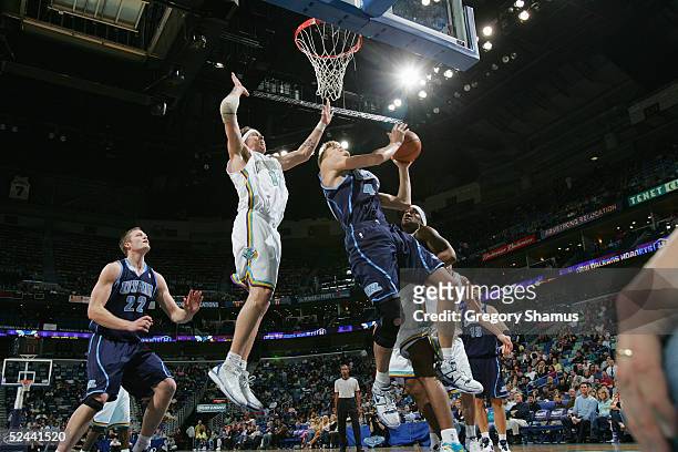 Andrei Kirilenko of the Utah Jazz shoots near Chris Andersen of the New Orleans Hornets during the game on March 4, 2005 at the New Orleans Arena in...