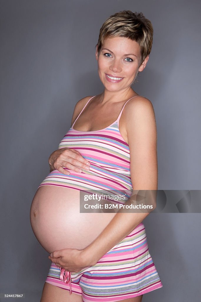 Pregnant woman holding stomach with hand