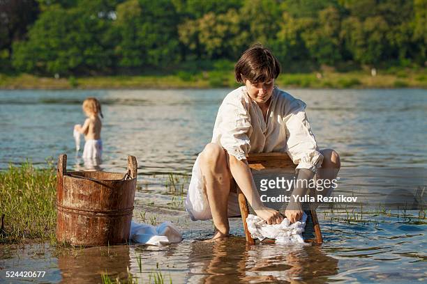 mother and daughter washing laundry - washboard laundry stock pictures, royalty-free photos & images
