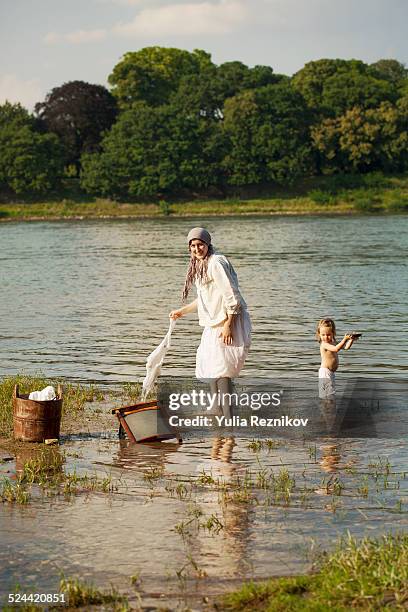 mother and daughter washing laundry - washboard laundry stock pictures, royalty-free photos & images