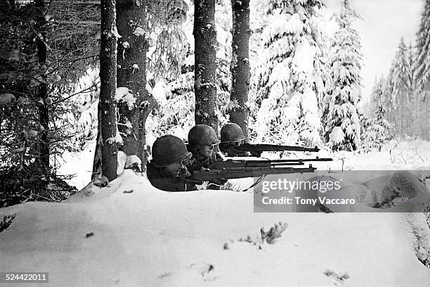 Three US infantrymen in the snow during the Battle of the Bulge, Ardennes, Belgium, World War II, January 1945.