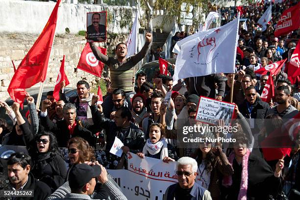 Protestors rising photo of Belaid, flags and screaming. On the occasion of the commemoration of the first anniversary of the assassination of Chokri...