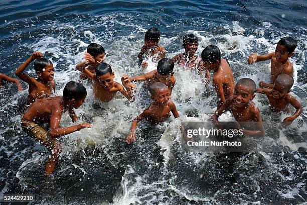 Children takes shower and make fun in the river Burigonga to get release from extreme heat of the summer, in Dhaka, Bangladesh, on April 26, 2016....