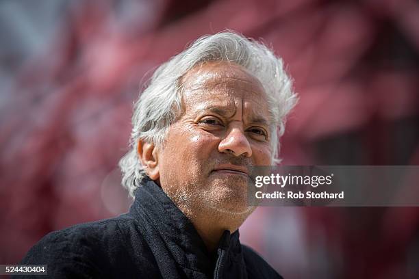 Anish Kapoor poses for photographers in front of the ArcelorMittal Orbit tower at the Queen Elizabeth Olympic Park on April 26, 2016 in London,...