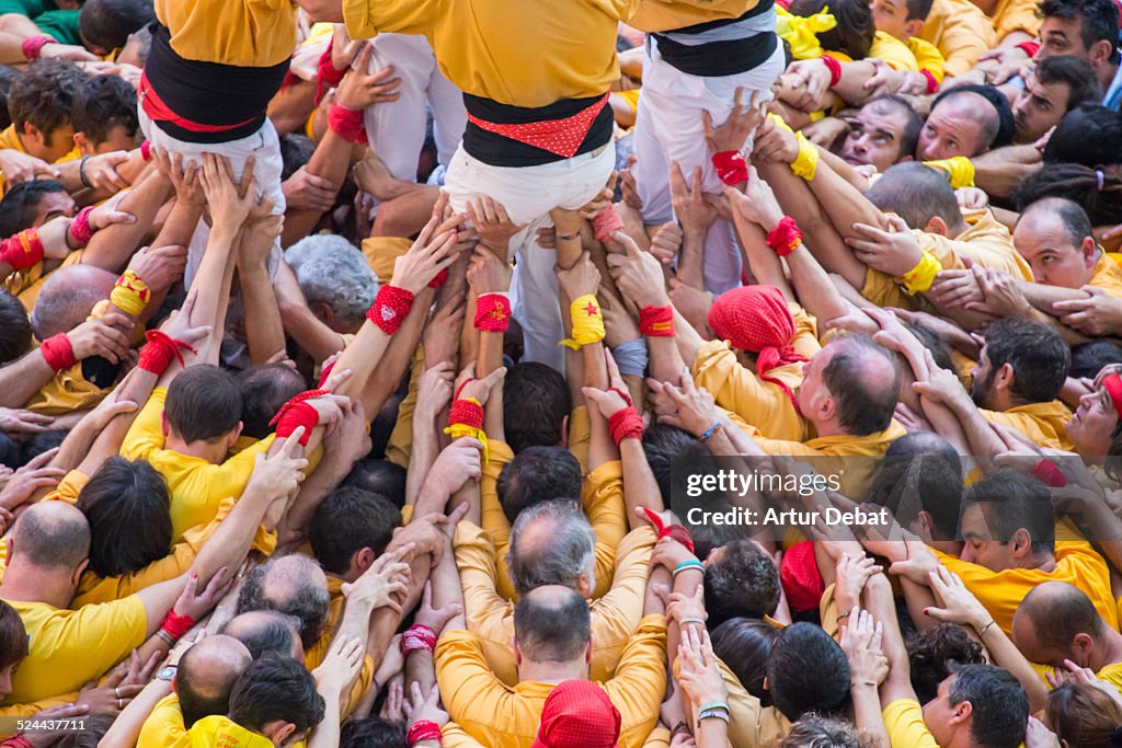 Yellow human tower "Castellers" view from above.