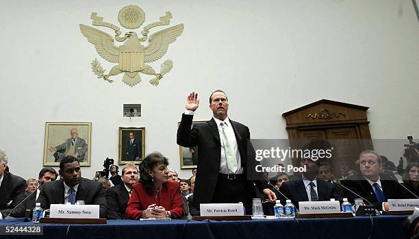 Baseball player Mark McGwire is sworn in as Sammy Sosa and Rafael Palmeiro and Curt Schilling look on March 17, 2005 during a House committee that is...