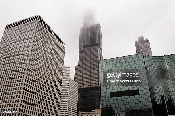 The top of the Sears Tower is lost in the clouds as the landmark skyscraper stands among other buildings March 17, 2005 in downtown Chicago,...
