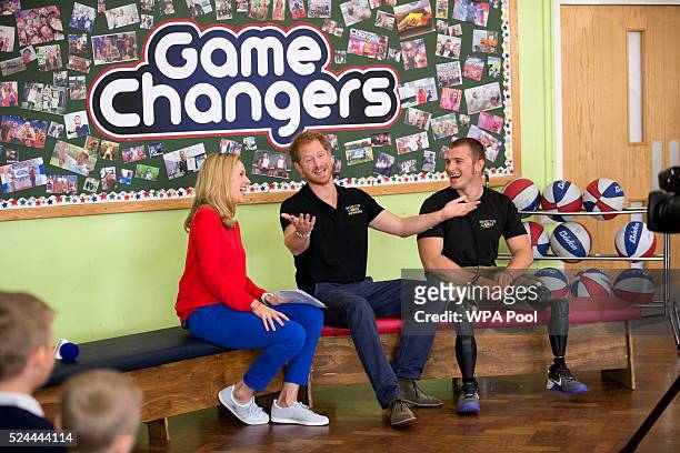 Prince Harry gestures after being asked by one of the audience of children if he will ever become King, as he sits flanked by presenter Di Dougherty...