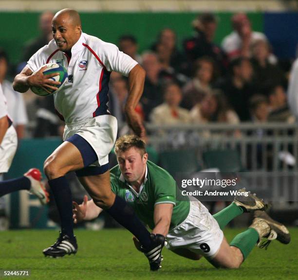 Jason Raven of the United States evades a tackle by Ireland's James Norton during their match on day one of the Rugby World Cup Sevens held at Hong...