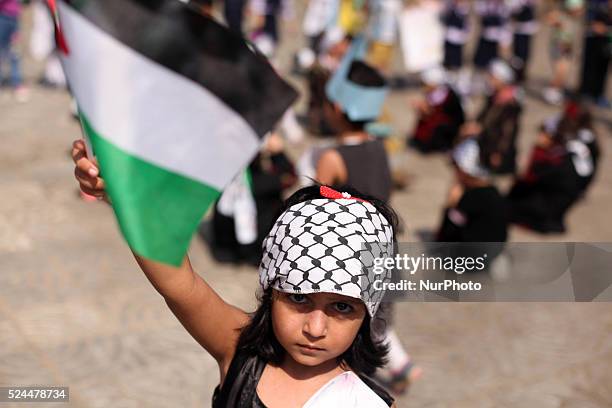 Palestinians children raise the Palestinian flag during a ceremony in Gaza City, on October 1, 2015. The Palestinian flag was raised at UN...