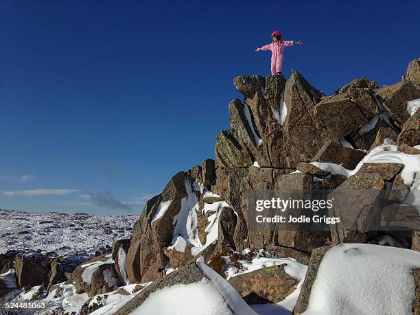 child with arms outstretched on rocks at the snow - ben lomond stock pictures, royalty-free photos & images