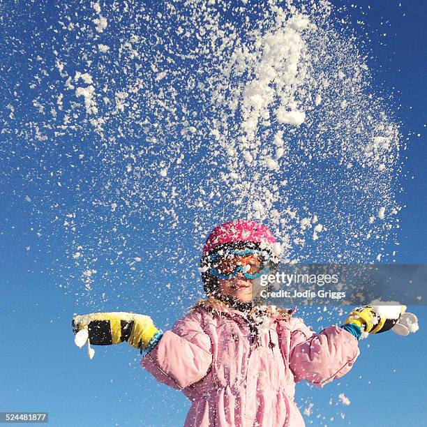 child throwing a handful of snow up into the air - winter coat stock pictures, royalty-free photos & images