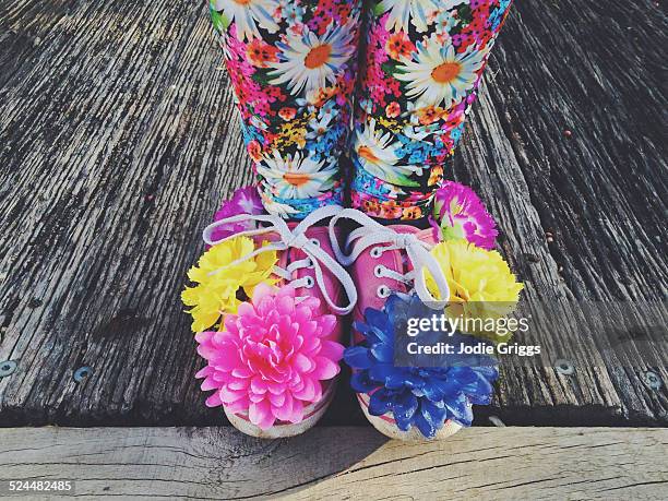 child wearing shoes covered in colourful flowers - bunte hose stock-fotos und bilder