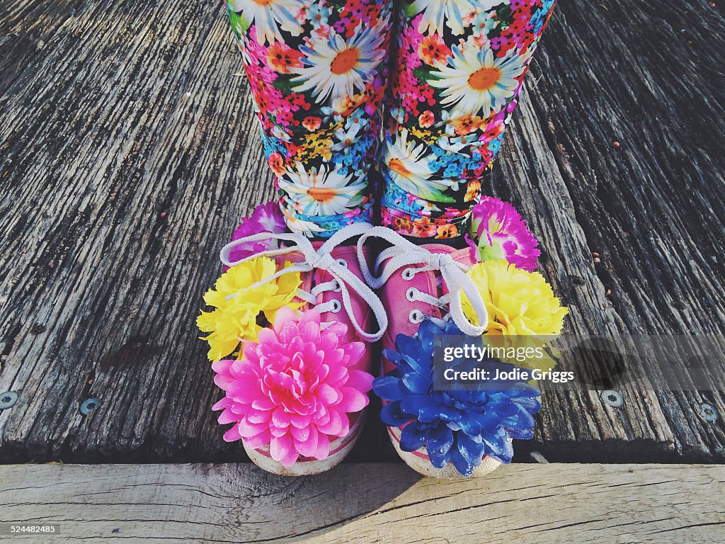 Child wearing shoes covered in colourful flowers