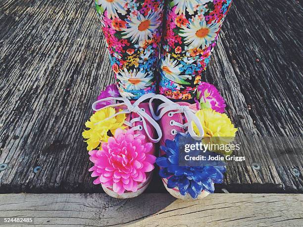 Child wearing shoes covered in colourful flowers