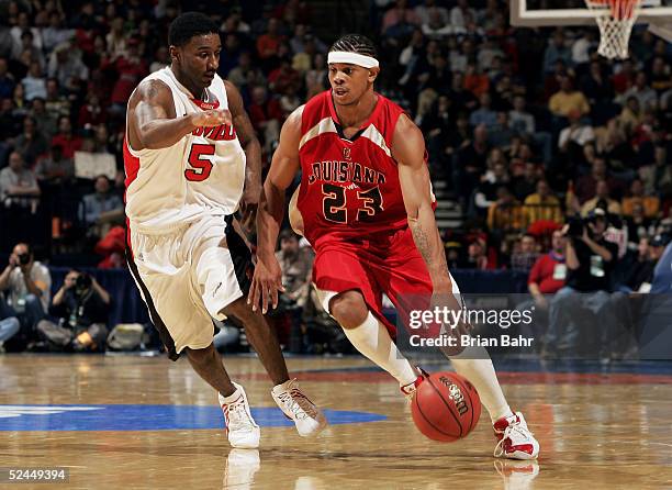 Dewayne Mitchell of the Louisiana-Lafayette Ragin' Cajuns drives past Taquan Dean of the Louisville Cardinals in the first round of the NCAA Division...