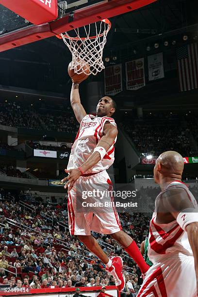 Tracy McGrady of the Houston Rockets dunks against the Boston Celtics as teammate David Wesley watches on March 18, 2005 at the Toyota Center in...