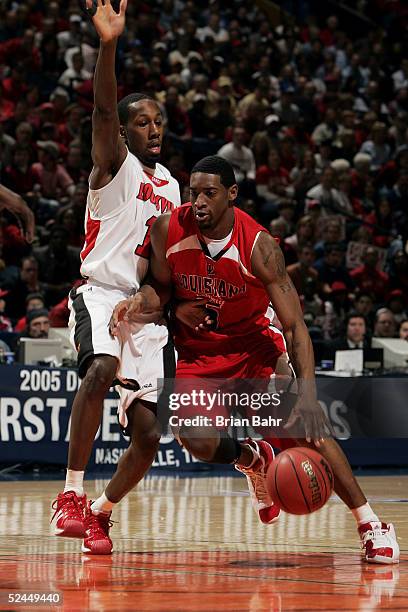 Brandon Jenkins of the Louisville Cardinals tries to stop Orien Greene of the Louisiana-Lafayette Ragin' Cajuns in the first round of the NCAA...