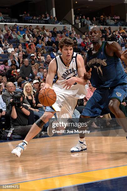 Mike Miller of the Memphis Grizzlies drives to the basket against the defense of Kevin Garnett of the Minnesota Timberwolves on March 18, 2005 at...