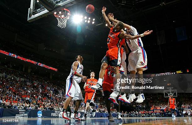 Charles Lee of the Bucknell Bison shoots the ball with two Kansas Jayhawks defenders on his back in the first round of the NCAA Men's Basketball...