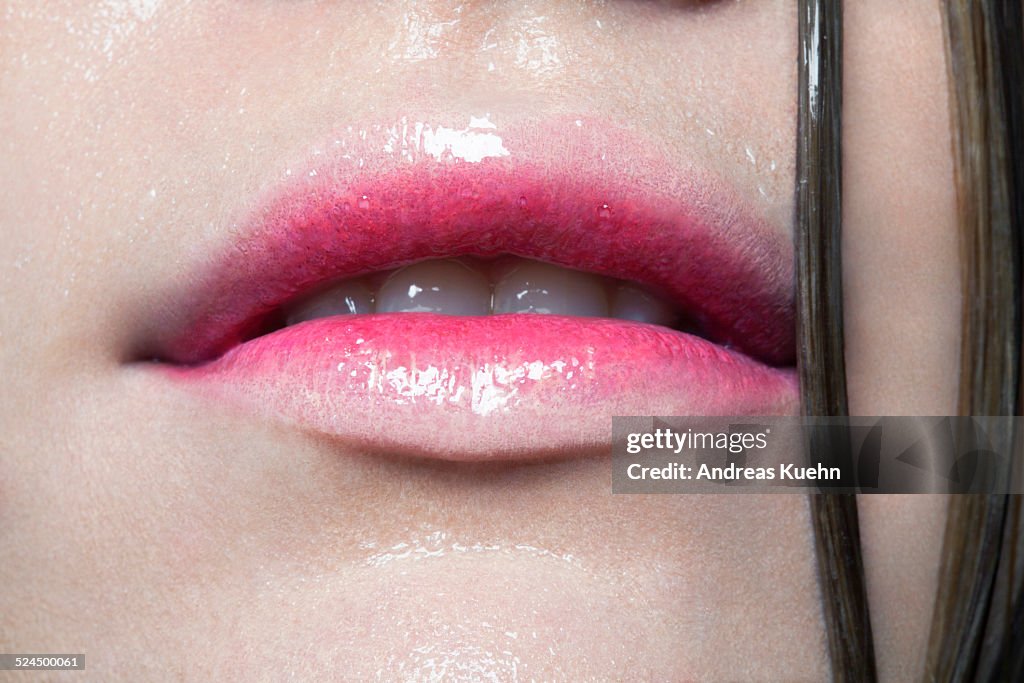 Tight crop of young woman's juicy red lips.