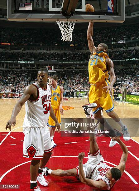 Jamaal Magloire of the New Orleans Hornets tries to shoot after fouling Tyson Chandler of the Chicago Bulls as Antonio Davis of the Bulls looks for a...