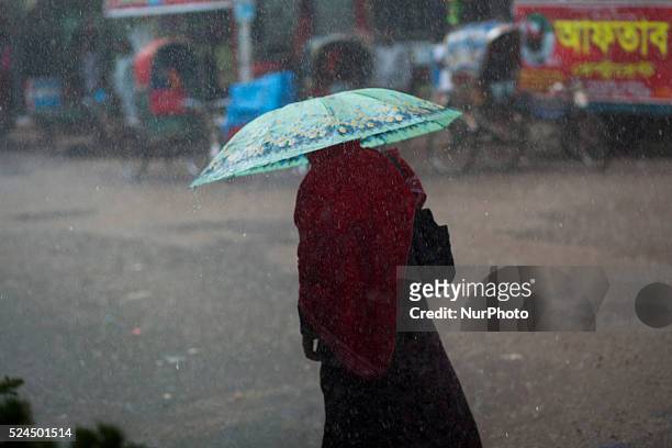 An women walking on road during heavy rain in Dhaka