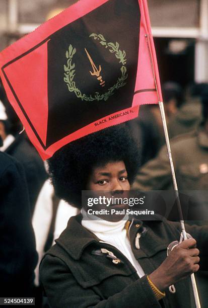 Outside the Rayner Funeral Home, a woman holds a Black American Heritage flag while waiting to pay last respects to slain Black Panther Party leader...