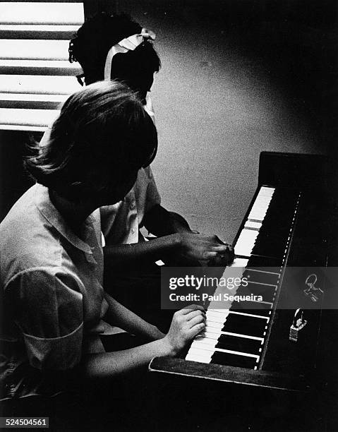 Staff member encourages a detainee to play the piano, at the Audy Home Juvenile Detention Center, Chicago, Illinois, 1968.