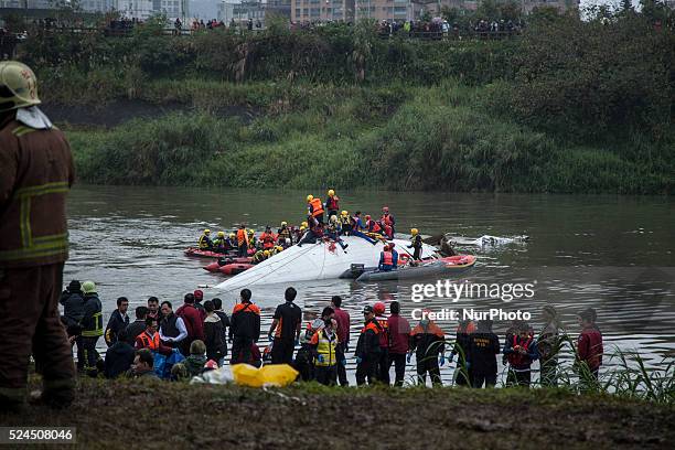 Rescue team and debris of a commercial airplane ATR72 operated by a Taiwanese airlines TransAir, that crashes into a river shortly after take off on...