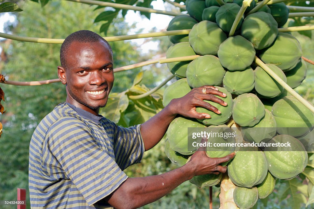 A young person showing a papaya