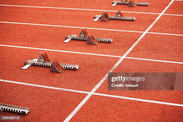 some starting block on running track - startblok atletiek stockfoto's en -beelden