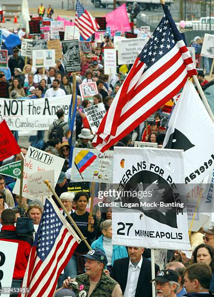 Marchers carry flags and signs during a demonstration to mark the second anniversary of the U.S.-led invasion of Iraq March 19, 2005 in Fayetteville,...