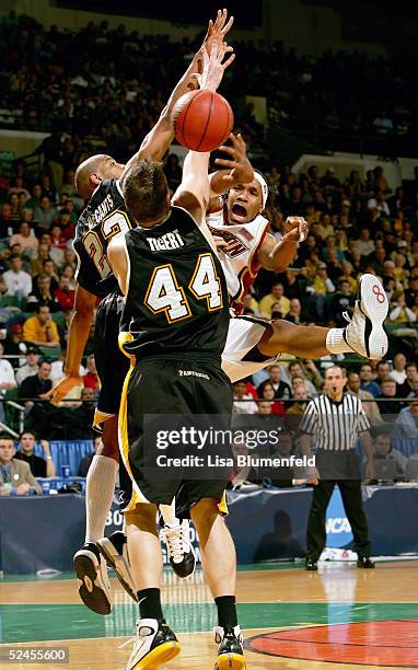 Jermaine Watson of the Boston College Eagles passes under pressure from Adrian Tigert and Ed McCants of the Wisconsin-Milwaukee Panthers during the...