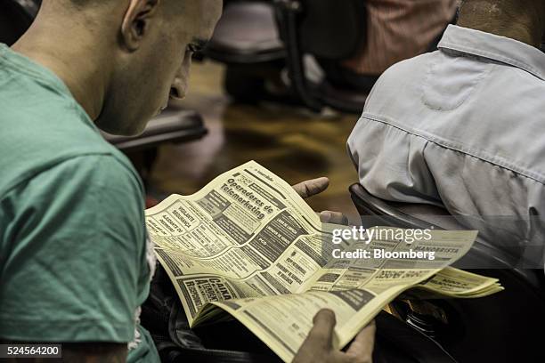 Man reads job listings while waiting at the Centro Apoio ao Trabalho government unemployment center in Sao Paulo, Brazil, on Monday, April 25, 2016....