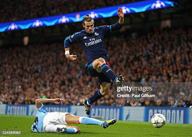Gareth Bale of Real Madrid CF hurdles the challenge from Jesus Navas of Manchester City during the UEFA Champions League Semi Final first leg match...