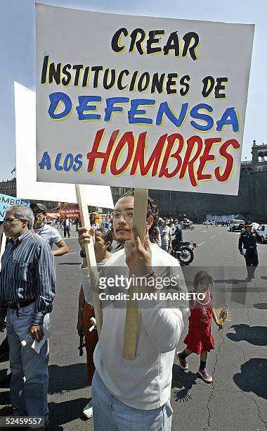 Un hombre sostiene un cartel durante una manifestacion en rechazo al feminismo, en el centro historico de Ciudad de Mexico, el 20 de marzo de 2005....