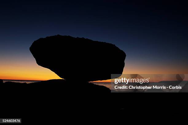 Balance rock on the shore of Graham Island, at sunrise on Skidegate Inlet.