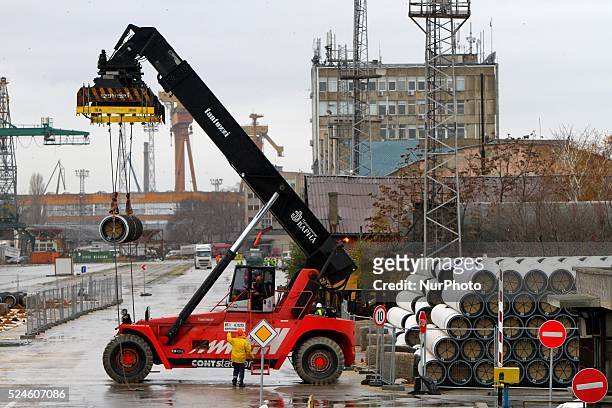 Workers arrange pipes delivered for construction of the South Stream gas pipeline and load them on a ship for unknown direction at the Black sea...