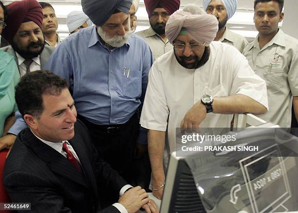 Punjab Chief Minister Amrinder Singh watches as US personal computer giant Dell Inc. Chairman Michael Dell gives some explanations on the Dell system...