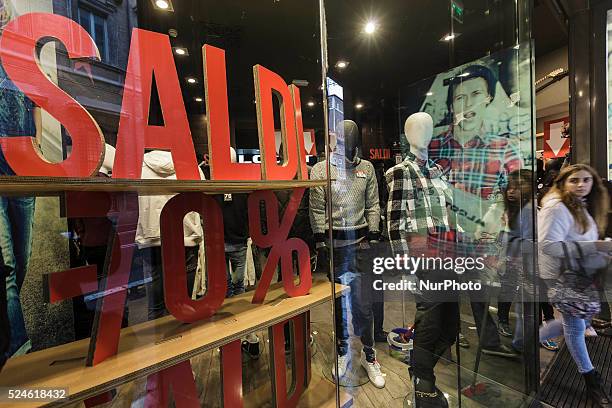 Woman walks past a shop window offering generous discounts during the winter sales in downtown Rome, Italy, on January 5, 2016. The first day of...