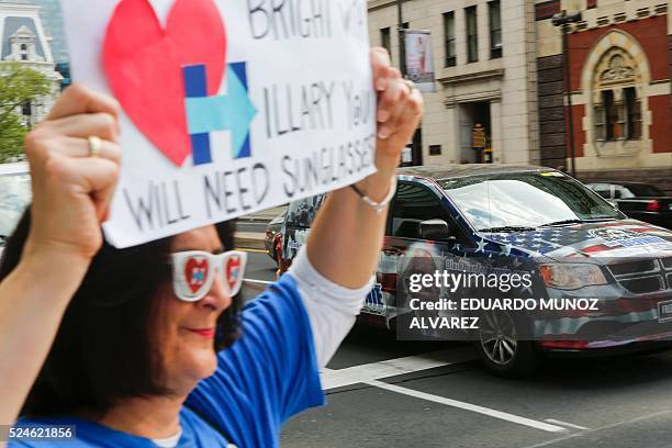 Car with the face of Democratic presidential candidate Bernie Sanders drives past a supporter of Democratic presidential candidate Hillary Clinton on...