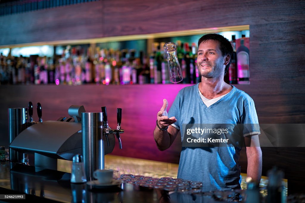 Smiling barkeeper filling a glass