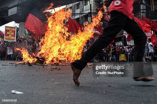 Protesters run around the burnt effigy shouting their protests at the historic Mendiola Bridge in San Miguel, Manila on Saturday, 30 November 2013....